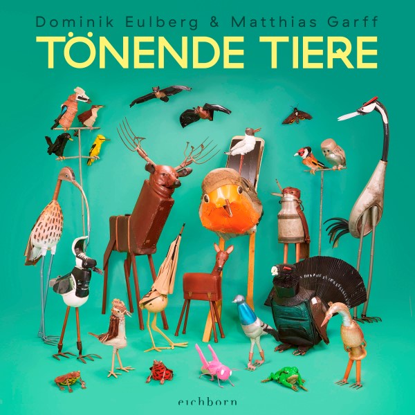 Cover des Buches "Tönende Tiere" mit bunten Tierplastiken auf grünem Grund.